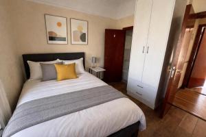 a bedroom with a large white bed with yellow pillows at The Malting House in Skerries