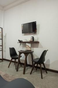 a room with two chairs and a table and a tv at Dimora Hideout in Homagama