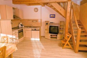 a kitchen with a staircase and a television in a room at Wohlfühlbauernhof in Geslau