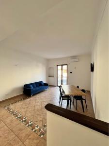 a living room with a table and a blue couch at Corso Messina in Crotone