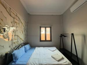 a small bedroom with a bed in a room at Batman guesthouse in Vientiane