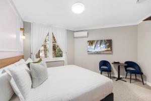 a bedroom with a bed and a table and chairs at Hotel Avonleigh in Katoomba