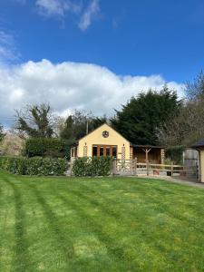 a yellow house with a large lawn in front of it at Mini haven in Oswestry