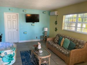 a living room with a couch and a tv on the wall at Jubilee Gardens Freeport in Freeport