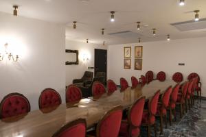 a conference room with a long table and red chairs at Gülce Köşk Otel & Restaurant in Amasya