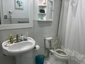 a white bathroom with a toilet and a sink at Jubilee Gardens Freeport in Freeport +52 photos