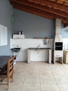 a kitchen with a table and a pizza oven at Recanto do sol in Brotas