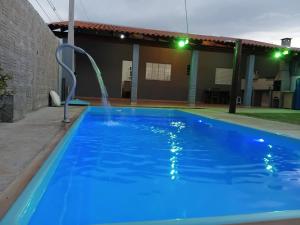 a blue swimming pool with a water fountain at Recanto do sol in Brotas +3 photos