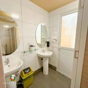 a bathroom with a sink and a mirror at Villa de Maria Suites in Binungan +72 photos