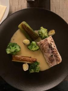 a plate of food with broccoli and meat and vegetables at Oázis Apartman in Orfű