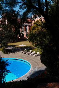 a swimming pool with lounge chairs and a house at Hotel Yak & Yeti in Kathmandu