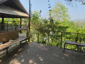 a deck with benches and a view of the forest at Volk resotel in Ban Nong Chaeng