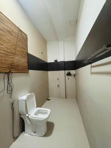 a bathroom with a toilet and a black and white wall at Dimora Hideout in Homagama +39 photos