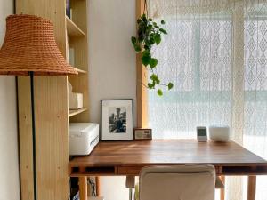 a wooden table with a lamp and a window at Gold Stream House in Seoul