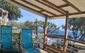a patio with blue chairs and a view of the ocean at Baia 1 in Drammont