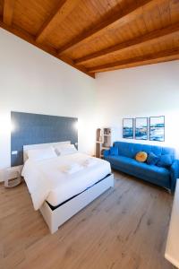 a bedroom with a large bed and a blue couch at Tenuta Marella in Santa Maria di Galeria