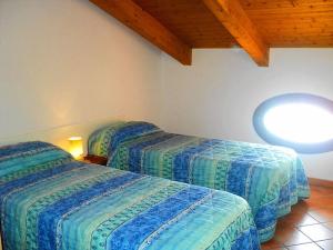 a bedroom with two beds and a wooden ceiling at Gelsomino home in Furore