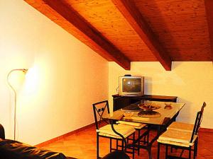 a dining room with a table with chairs and a tv at Gelsomino home in Furore