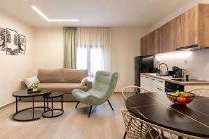 a kitchen and a living room with a table and chairs at Nouvelles Roses 1 in Nea Roda