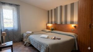 a hotel room with two beds in a bedroom at Hotel Piscina La Suite in Prossedi
