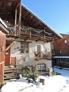 a house with a balcony on the side of it at Baita del Plan in Pragelato