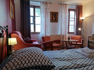 a bedroom with a bed and chairs and a table at Guest House Olšakovský in Český Krumlov