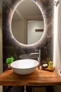 a bathroom with a white bowl sink and a mirror at Nouvelles Roses 1 in Nea Roda