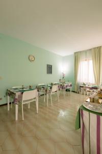 a dining room with tables and white chairs at Pollutrendy in Pollutri