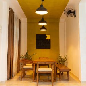 a dining room with a wooden table and benches at Dimora Hideout in Homagama