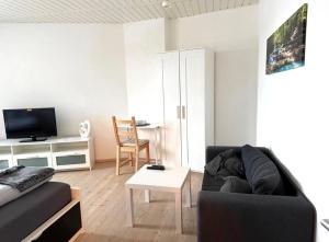 a living room with a couch and a table at Gästewohnung Pohlheim Grüningen in Pohlheim