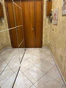 a room with a tiled floor and a wooden door at HermanHouse in Bacoli