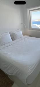 a bedroom with a white bed with a window at HermanHouse in Bacoli
