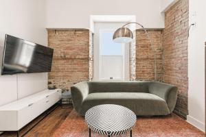 a living room with a couch and a tv at Meramont Hotel Downtown in Montreal +166 photos
