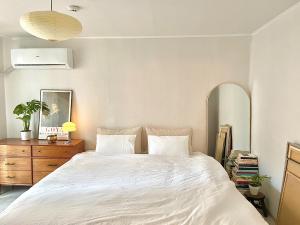 a bedroom with a large white bed and a dresser at Gold Stream House in Seoul +16 photos