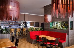 a restaurant with a red couch and a bar at Hotel ZRUČ in Zruč nad Sázavou