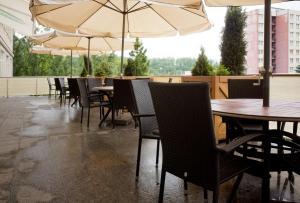 a row of tables and chairs with umbrellas on a patio at Hotel ZRUČ in Zruč nad Sázavou