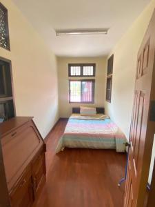 a bedroom with a bed and a window at Wandeehomehost in Chiang Mai