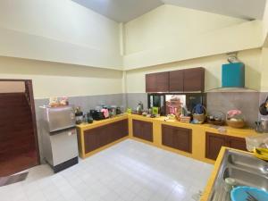 a large kitchen with a refrigerator and a sink at Wandeehomehost in Chiang Mai +13 photos