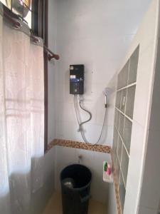 a bathroom with a shower with a black toilet at Wandeehomehost in Chiang Mai
