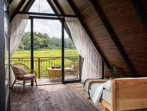a bedroom with a bed and a balcony with a view at Mango Liyadda Villa in Dambulla