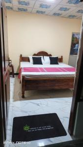 a bed in a room with a sign on the floor at Ashi Retreat in Dambulla