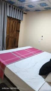 a large bed in a room with a wooden door at Ashi Retreat in Dambulla