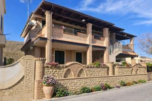 a house with a stone fence and a skateboard at Cala Greca Case Vacanze in Capo Rizzuto