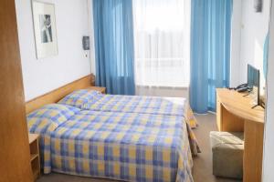 a hotel room with a bed and a desk and window at Neptune Hotel in Saints Constantine and Helena