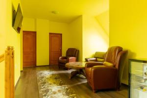 a living room with two chairs and a table at Írisz Vendégház in Lăzarea