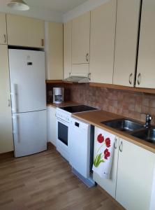 a kitchen with white appliances and a sink at Lägenhet Sandåsvägen in Mariehamn