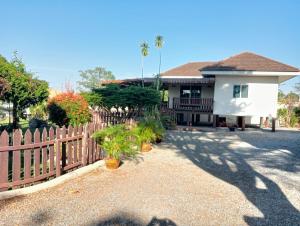 a fence in front of a house with plants at TRANQUILITY Resort in Nong Prue