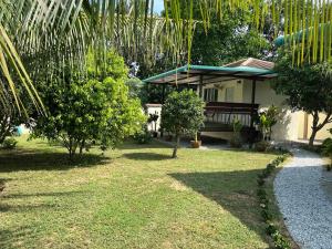 a house with a yard with grass and trees at TRANQUILITY Resort in Nong Prue