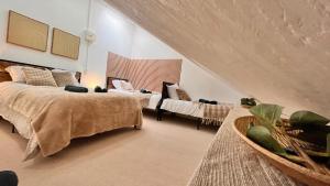 a bedroom with two beds and a couch and a chair at Villa Le Régis, des moments simples et vrais in Le Mont-Dore