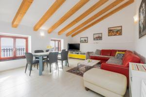 a living room with a red couch and a table at Apartment Seafront Mia in Umag